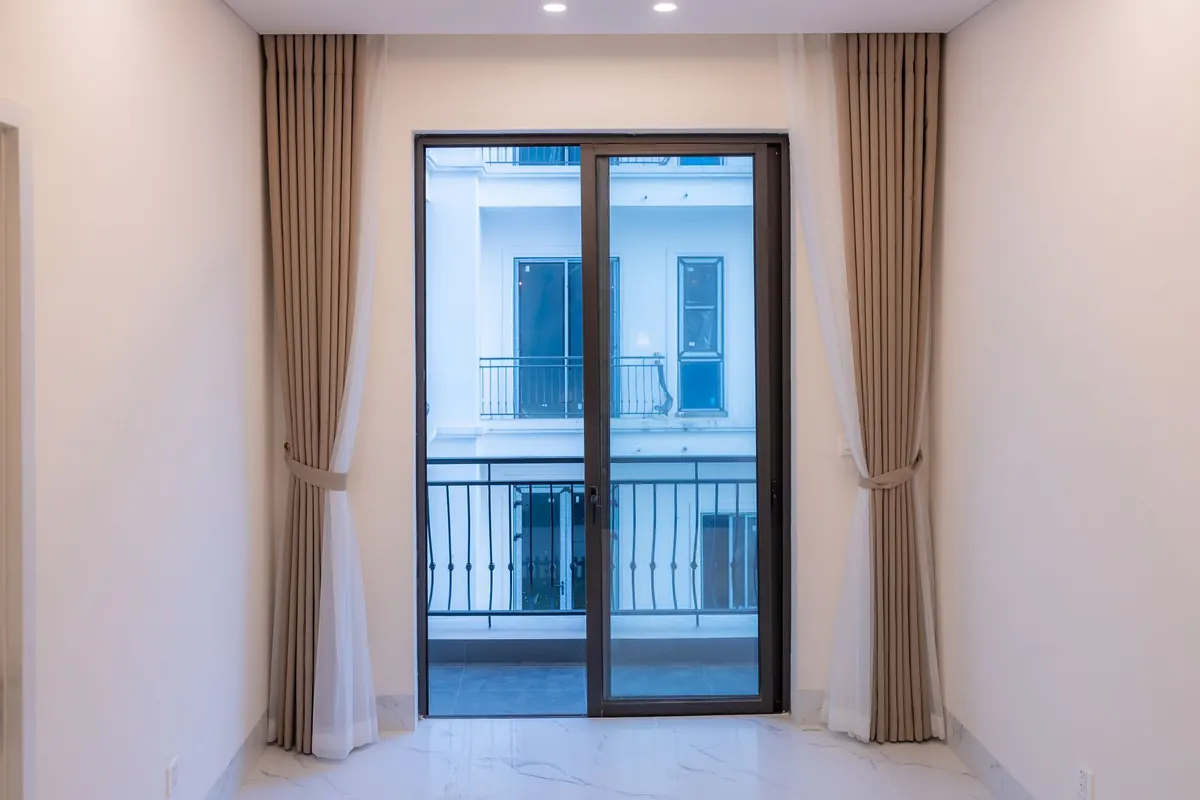 A sliding glass door at the end of an empty room