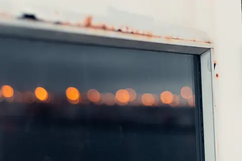 Close view of a window frame edge where the frame meets the glass