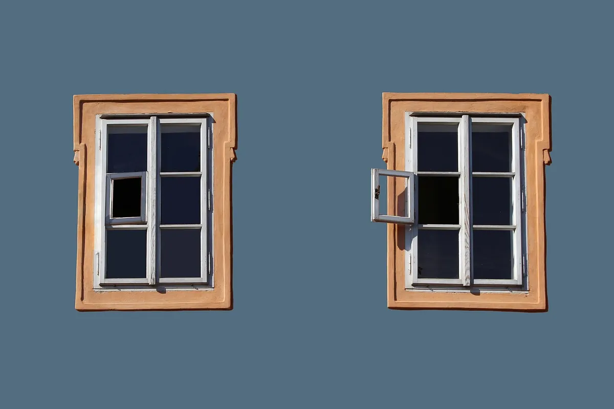 Framed residential windows on an exterior wall, showing different glass and frame types