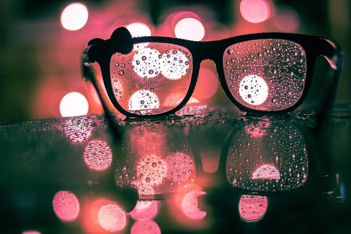 Hard-water droplets and mineral spots drying on a pane of glass