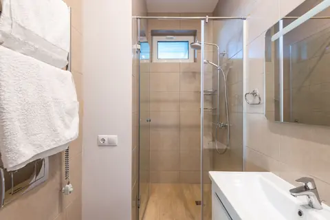 A glass shower enclosure in a bright bathroom