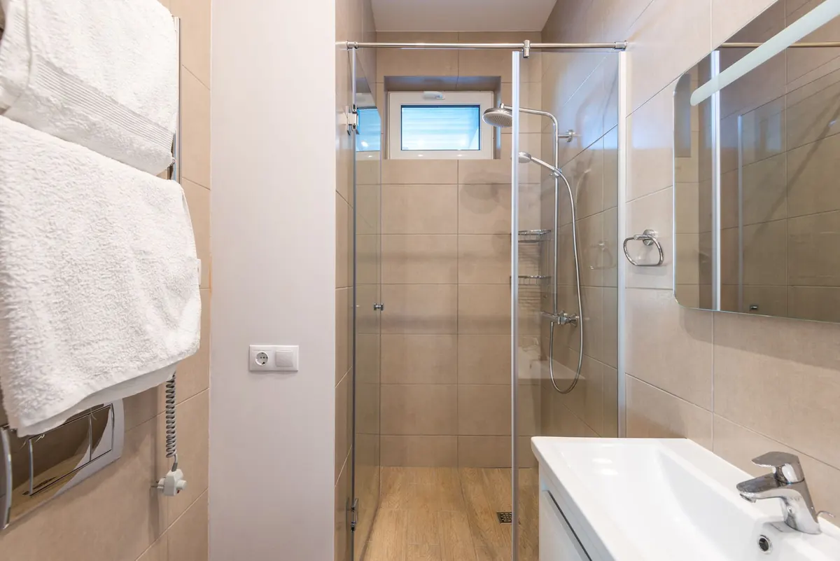 A glass shower enclosure in a bright bathroom