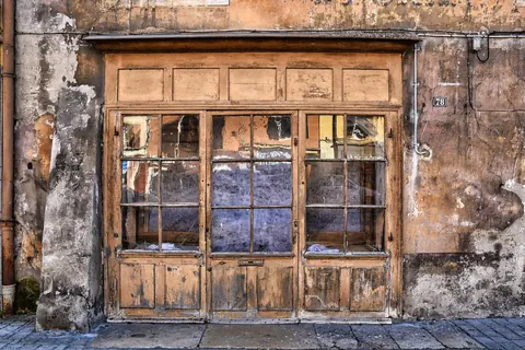 An old storefront with weathered wooden frames and original pre-war glass panes
