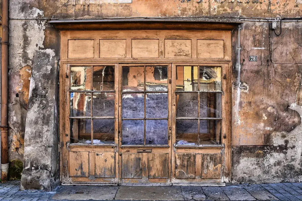 An old storefront with weathered wooden frames and original pre-war glass panes