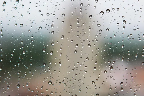 Water droplets standing on a pane of glass, the way shower glass looks in the minutes after use