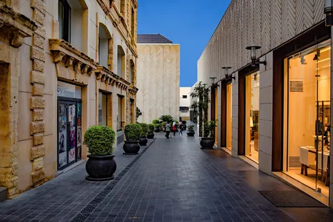 A row of storefront windows along a city commercial street at dusk