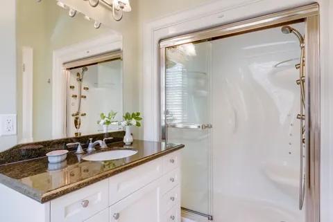 Modern bathroom with a frameless glass shower enclosure, the glass clear and freshly cleaned