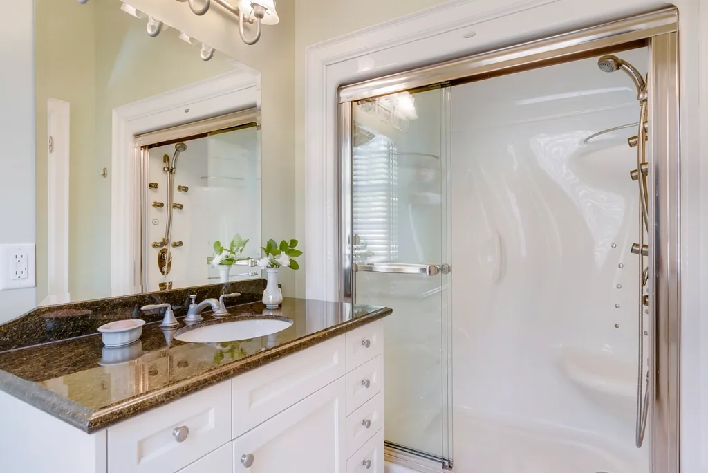 Modern bathroom with a frameless glass shower enclosure, the glass clear and freshly cleaned