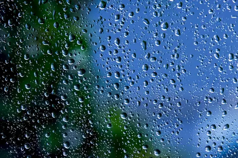 Water droplets beaded across a window pane after rainfall