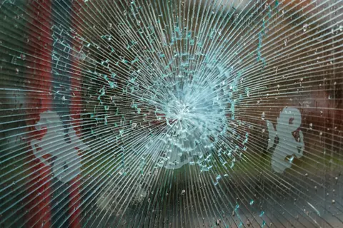 A pane of glass with cracks radiating from a single point