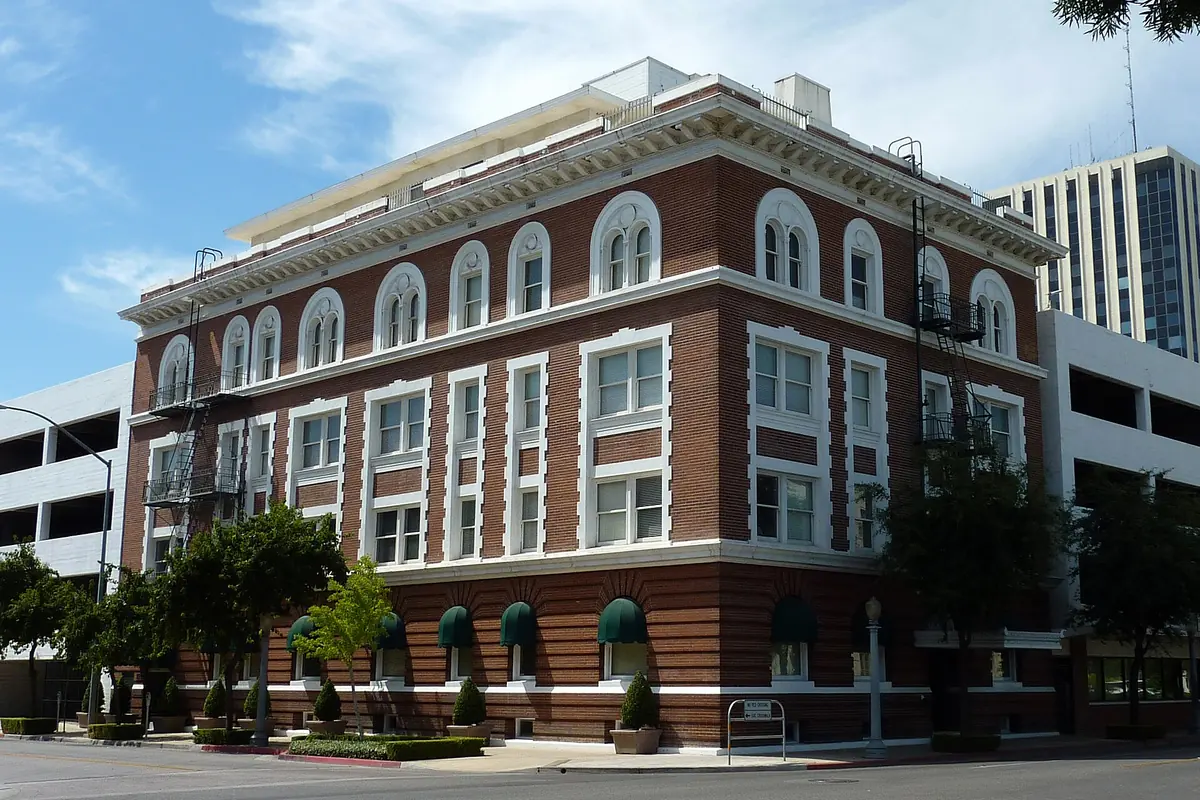 The red-brick Maubridge Apartments building in downtown Fresno under a blue sky