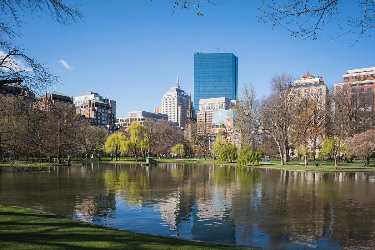 The blue-glass tower at 200 Clarendon rising behind the lagoon in Boston's Public Garden