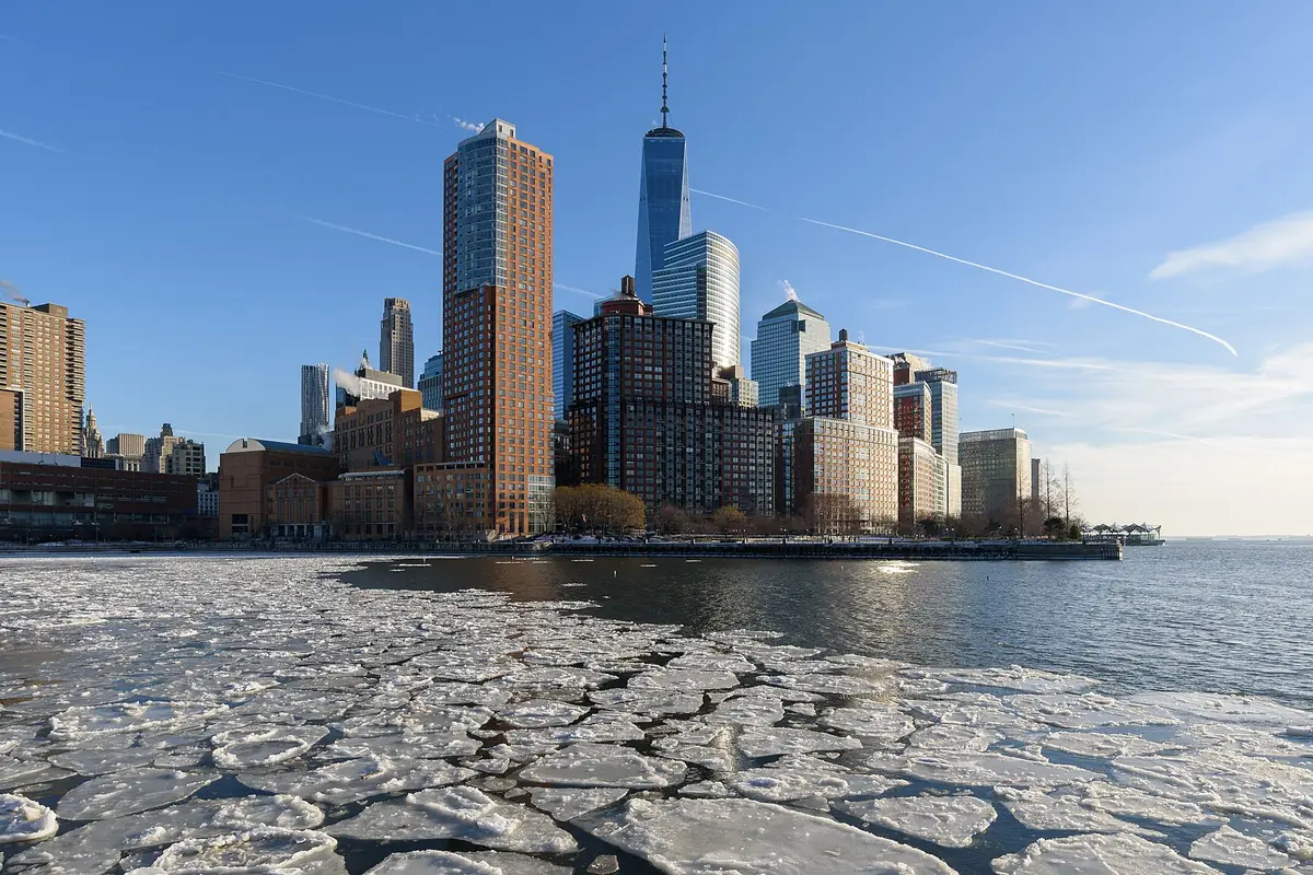Glass towers of Battery Park City and Lower Manhattan above broken ice on the Hudson River in January