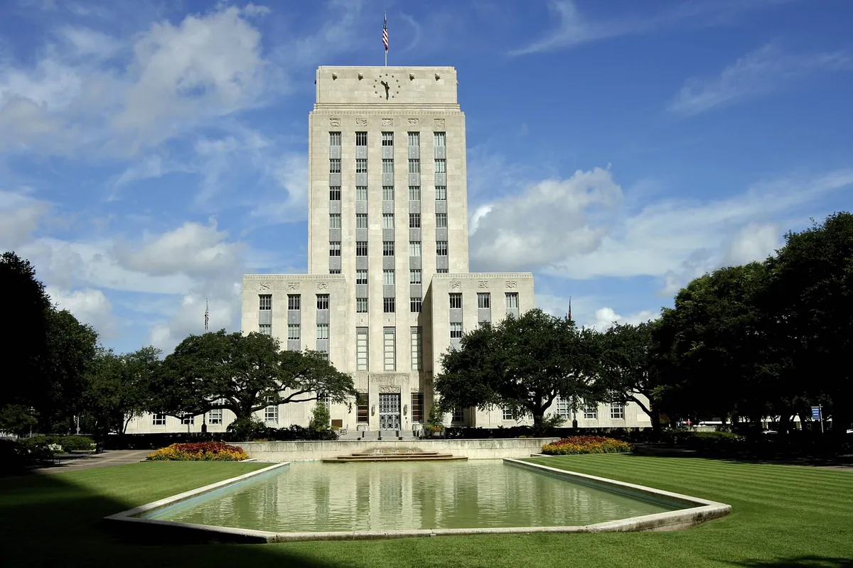 Houston City Hall's pale limestone tower rising behind its reflecting pool on a clear day