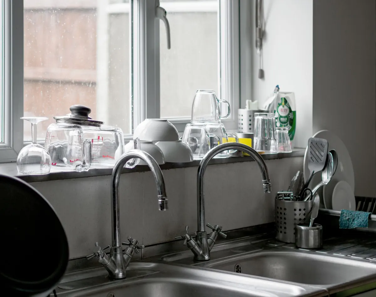 A kitchen sink and taps set beneath a window
