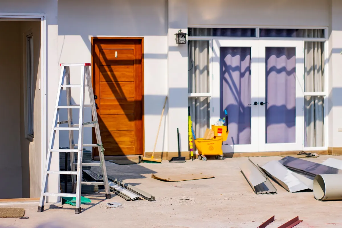 A stepladder standing in front of a house under renovation