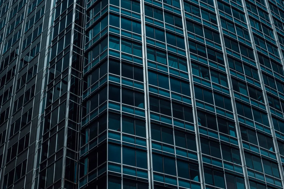A glass tower clad in a tinted blue-grey curtain wall